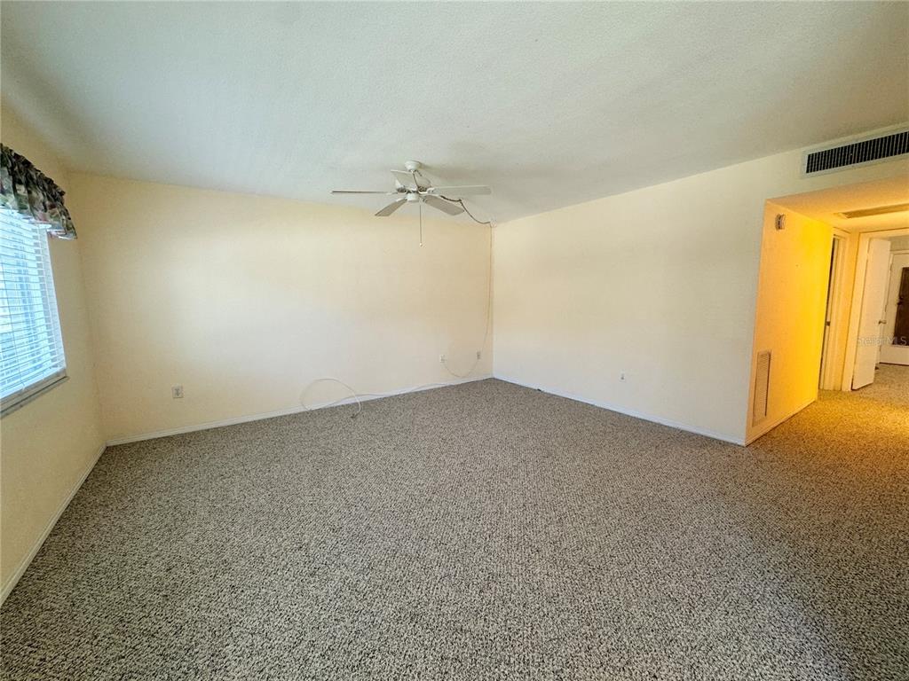 11201 80th Avenue, Unit 101 Seminole, FL 33772 - Photo 7 of 31 an empty room with a window and a ceiling fan