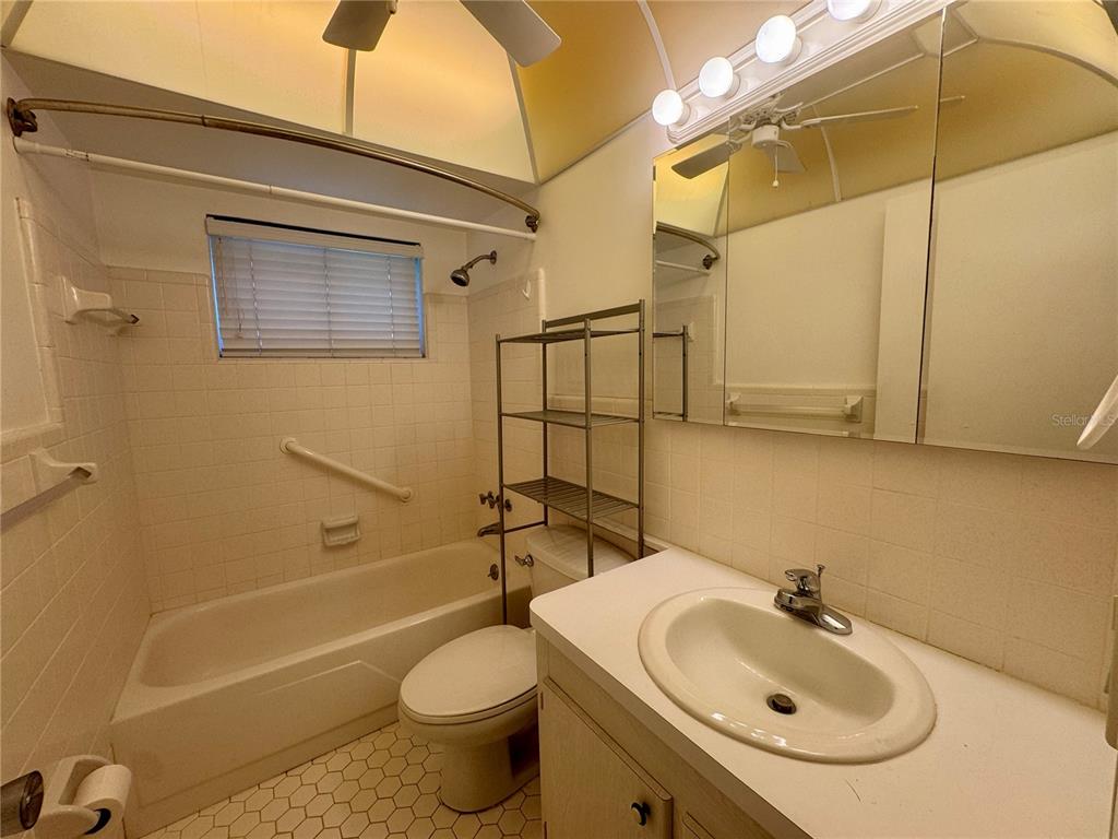 11201 80th Avenue, Unit 101 Seminole, FL 33772 - Photo 10 of 31 a bathroom with a sink a toilet and shower