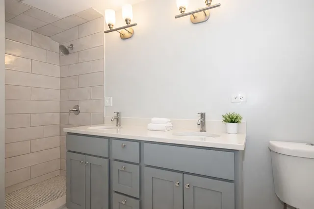 a bathroom with a sink a toilet and shower