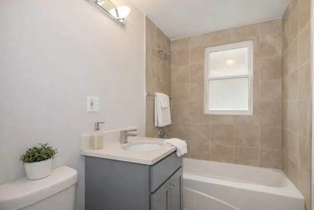 a bathroom with a sink vanity mirror and a bathtub