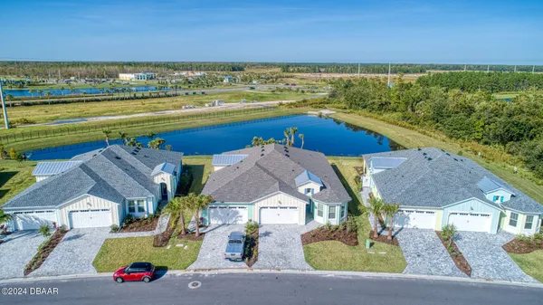 an aerial view of residential houses with outdoor space and ocean view