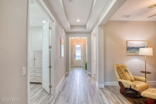 a view of a hallway to a livingroom with furniture and wooden floor