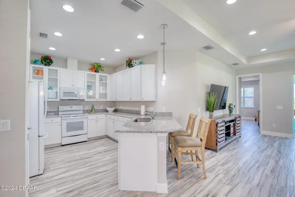 a kitchen with a sink a stove a center island and cabinets