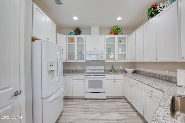 a kitchen with stainless steel appliances kitchen island granite countertop a sink and a refrigerator