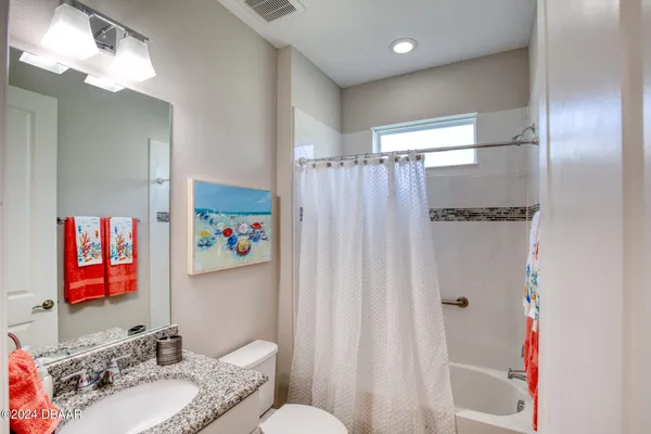 a bathroom with a sink vanity mirror and toilet