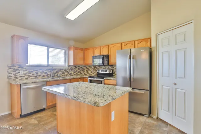 a kitchen with stainless steel appliances granite countertop a sink stove and refrigerator