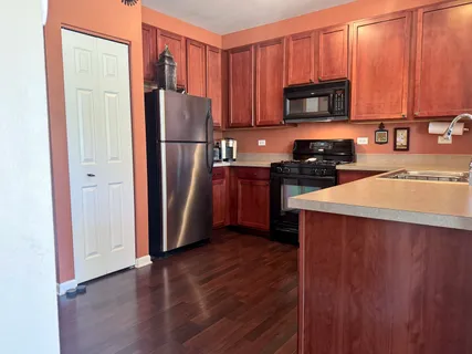 a kitchen with stainless steel appliances granite countertop a refrigerator microwave and sink