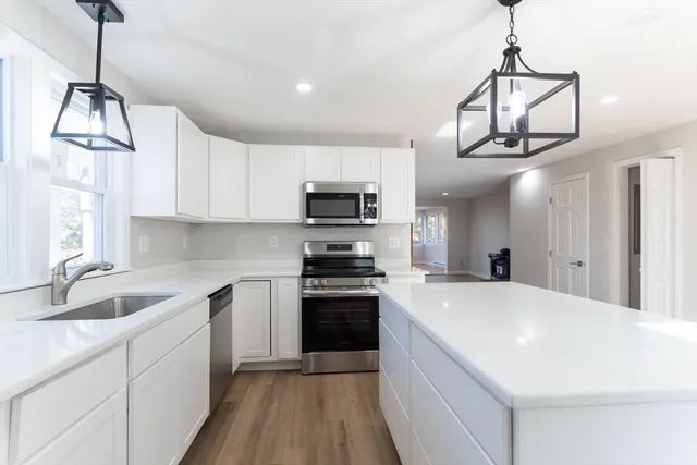 a kitchen with a sink stainless steel appliances and white cabinets