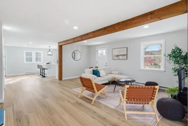 a kitchen with stainless steel appliances granite countertop a stove a sink a refrigerator a stove and white cabinets with wooden floor