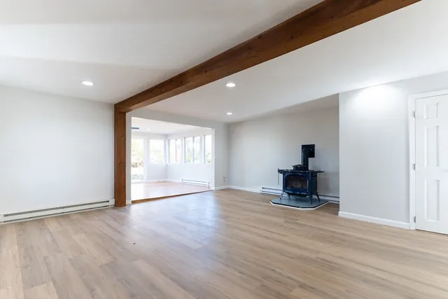 a view of empty room with wooden floor and furniture