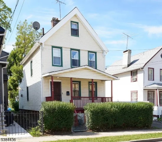 a view of a white house next to a yard
