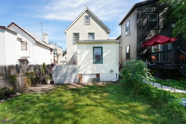 a view of a house with backyard and sitting area