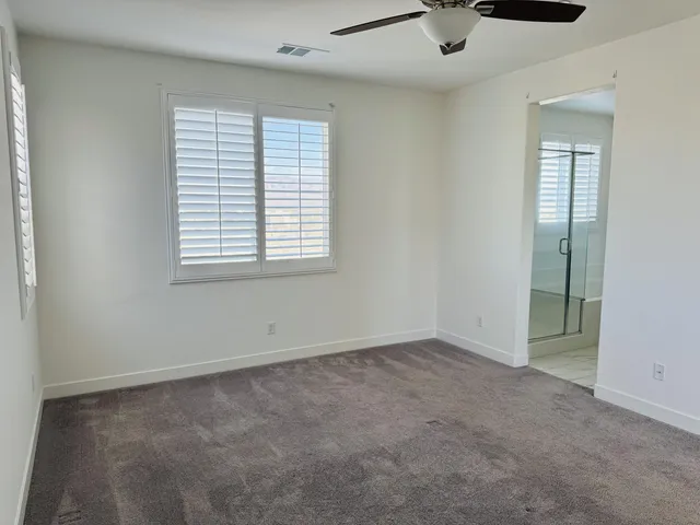 an empty room with a window and a fan