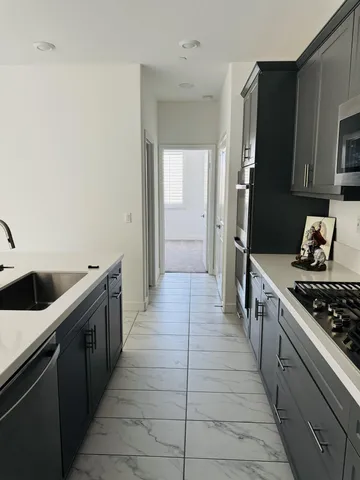 a kitchen with stainless steel appliances a stove and a sink