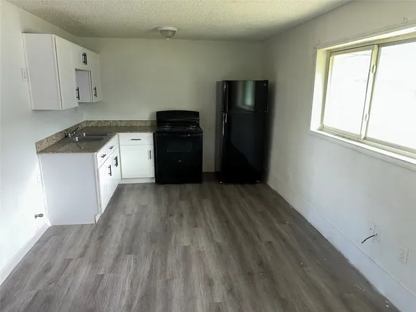 a kitchen with a refrigerator and a stove top oven