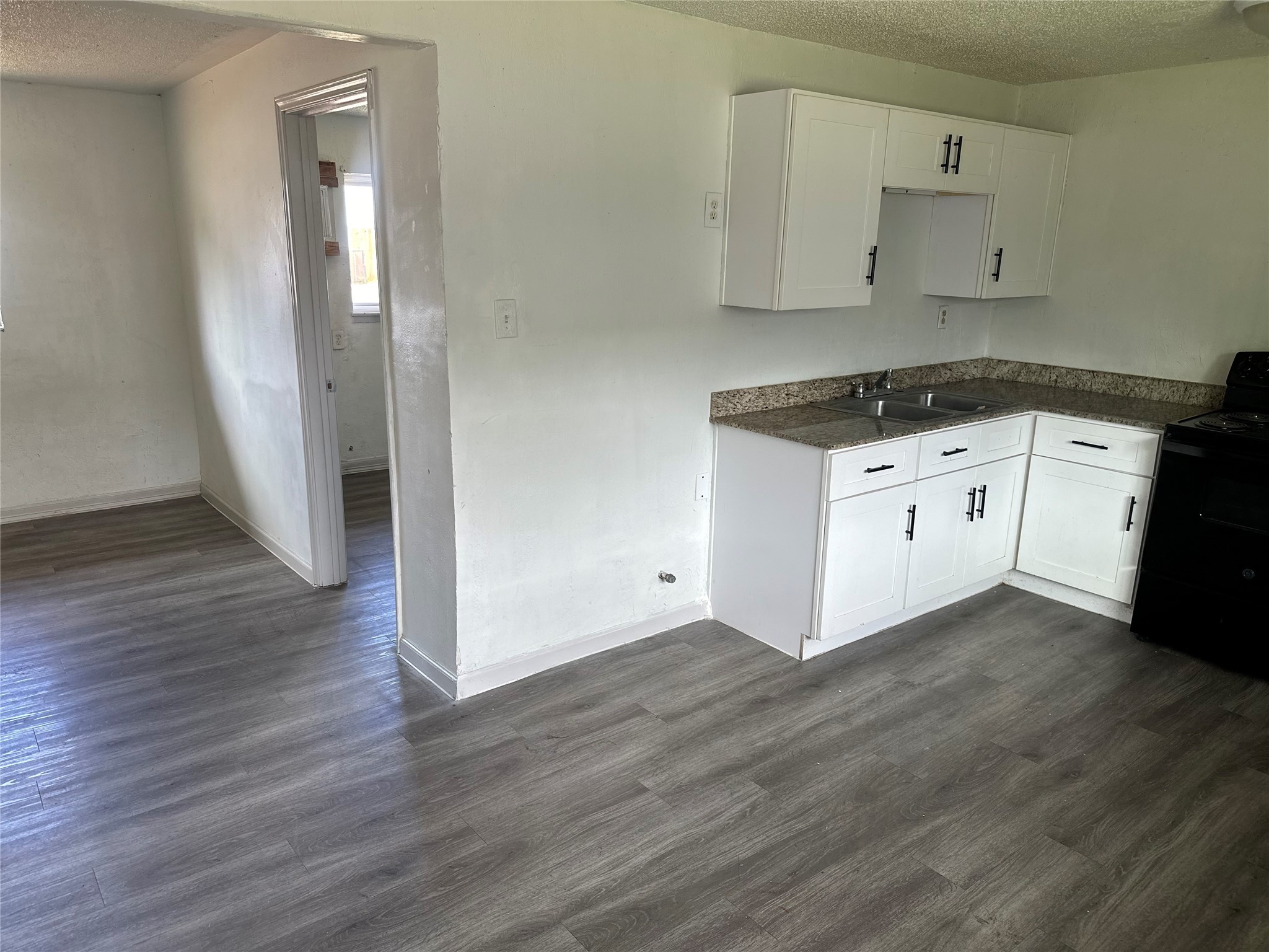 5405 Suez Street, Unit 2 Houston, TX 77020 - Photo 5 of 17 a kitchen with granite countertop white cabinets and black appliances