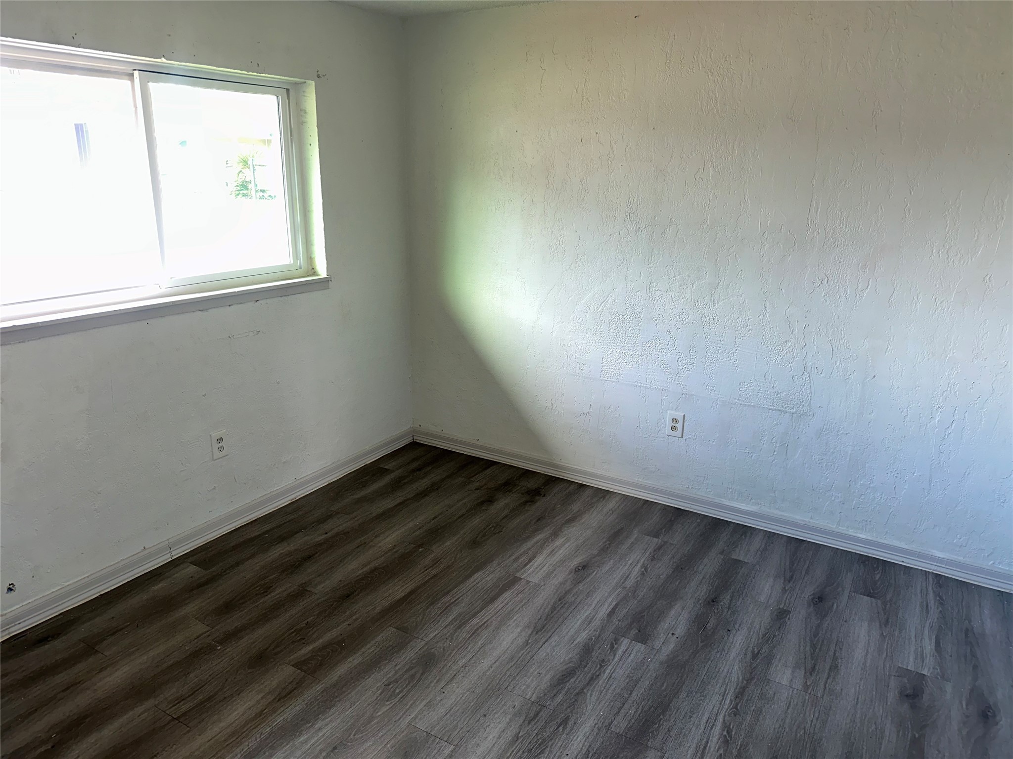 5405 Suez Street, Unit 2 Houston, TX 77020 - Photo 9 of 17 an empty room with wooden floor and windows