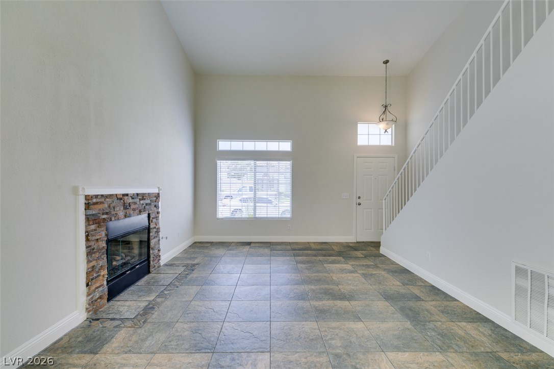 200 Luninborg Street Henderson, NV 89074 - Photo 12 of 40 A spacious living area offers towering ceilings, a stone fireplace, and abundant natural light.