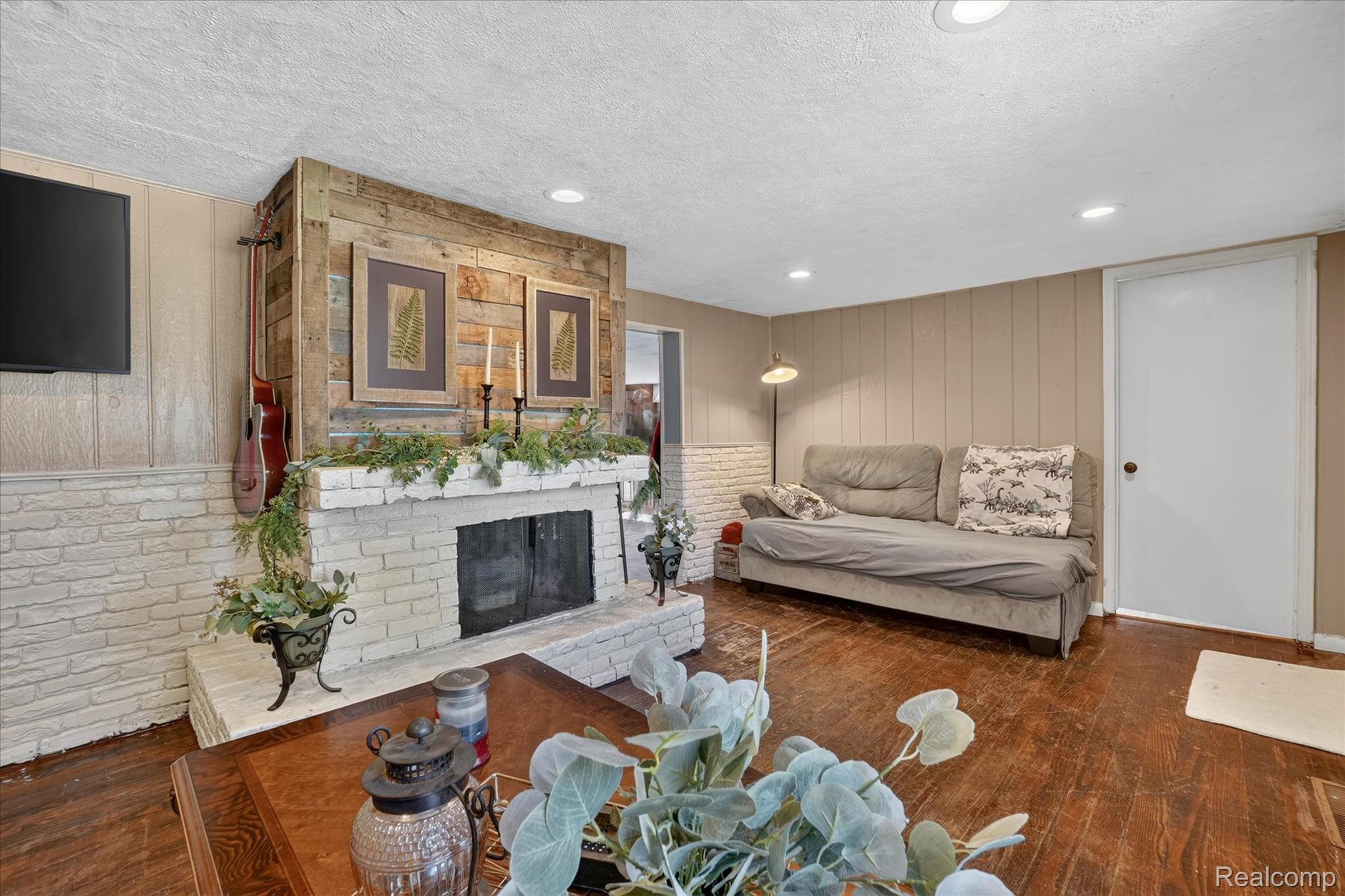 508 Deland Road Flushing, MI 48433 - Photo 7 of 38 Living space featuring a whitewashed brick fireplace with a wood-finish mantel and hearth