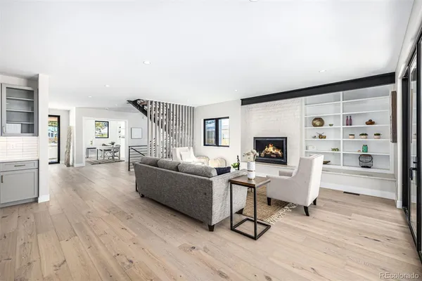 a living room with furniture a flat screen tv and wooden floor