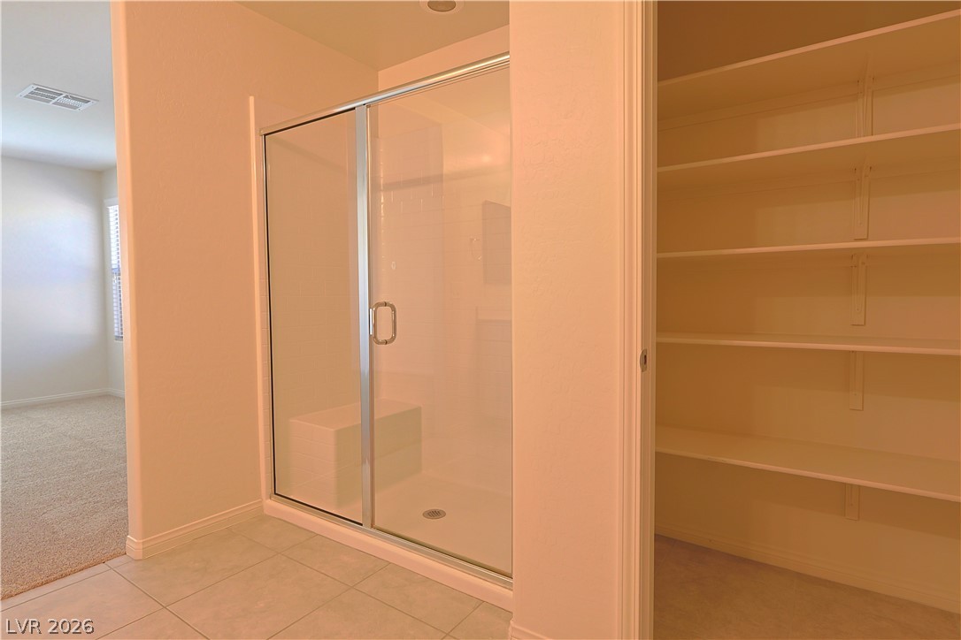 8663 Reynolds Spring Street Las Vegas, NV 89178 - Photo 21 of 32 A glass-enclosed walk-in shower sits adjacent to a spacious built-in linen closet.