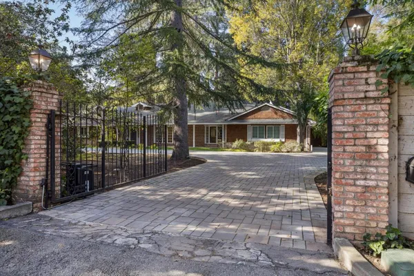 a front view of a house with a yard and trees