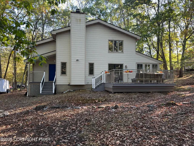 a view of a house with a yard and a large tree