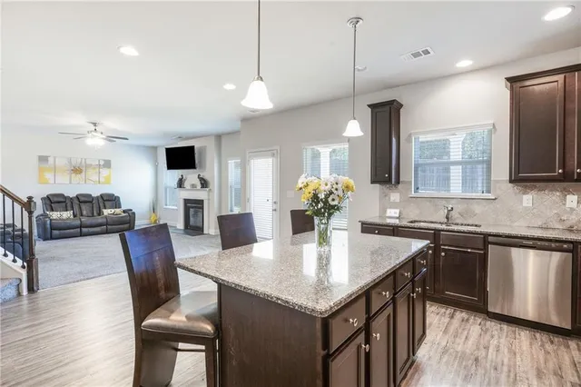 a kitchen with granite countertop a table chairs sink and wooden floor