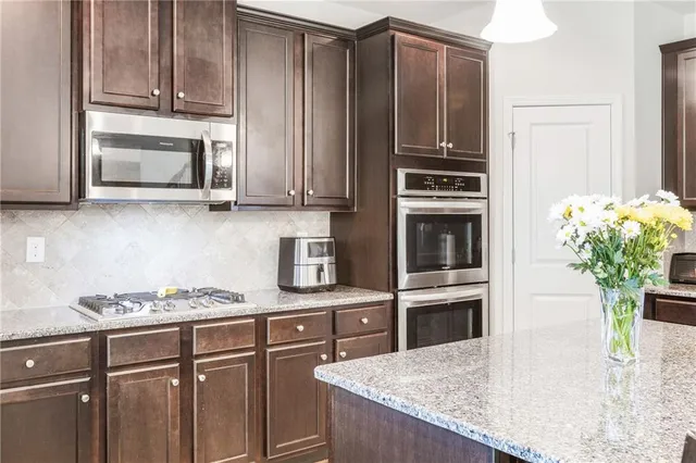 a kitchen with granite countertop a stove cabinets and microwave