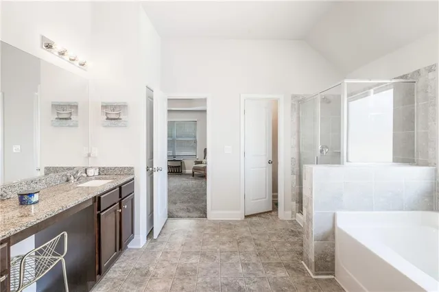 a spacious bathroom with a tub sink and mirror