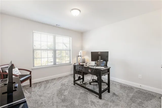 a view of a workspace with furniture and a window
