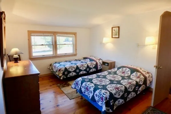 a bedroom with two beds and a window