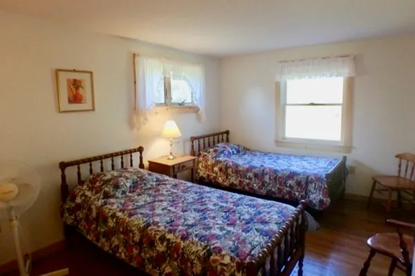 a bedroom with a bed window and wooden floor
