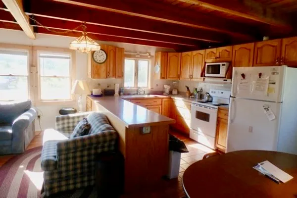 a living room with stainless steel appliances furniture and a large window