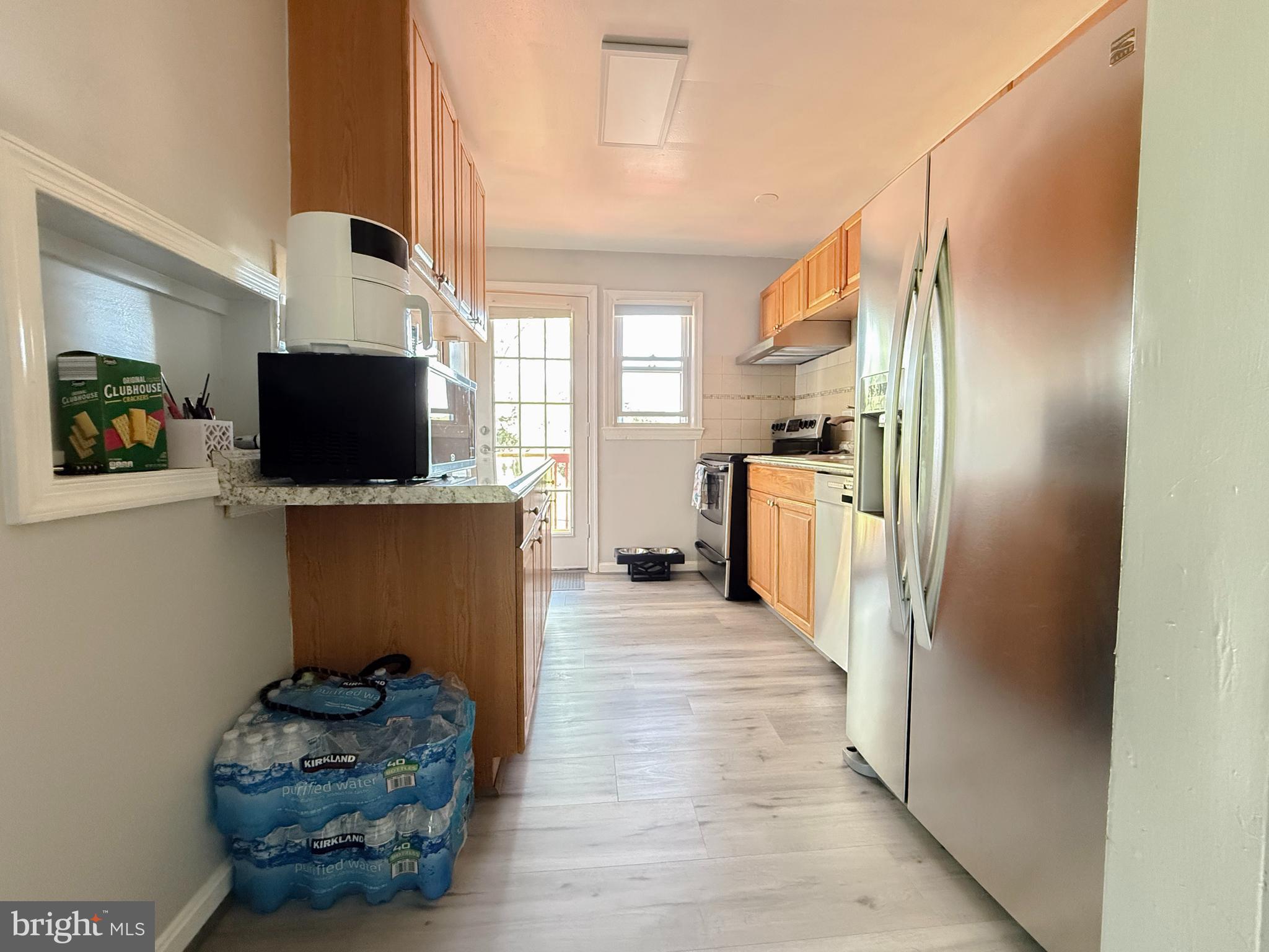 11601 Veirs Mill Road Wheaton, MD 20902 - Photo 12 of 30 a kitchen with stainless steel appliances kitchen island granite countertop a refrigerator and a stove