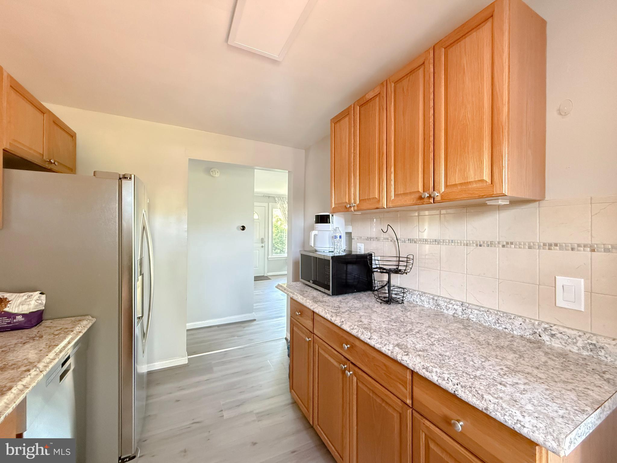 11601 Veirs Mill Road Wheaton, MD 20902 - Photo 14 of 30 a kitchen with granite countertop stainless steel appliances a sink a refrigerator and cabinets