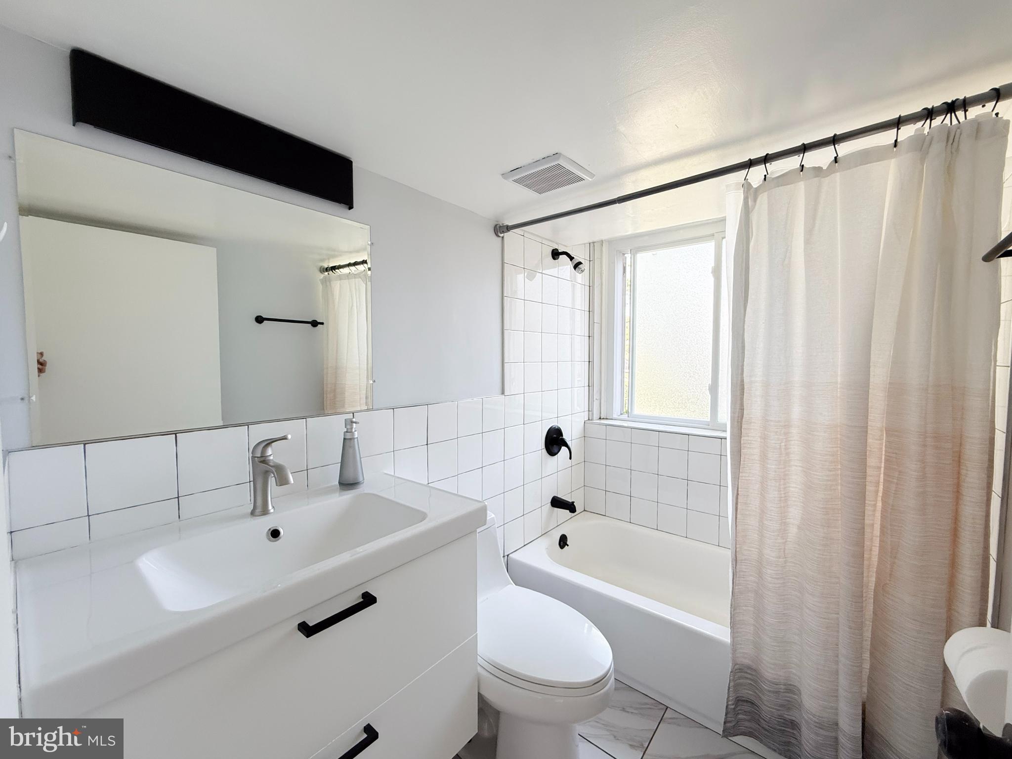 11601 Veirs Mill Road Wheaton, MD 20902 - Photo 21 of 30 a bathroom with a sink a toilet and a bathtub