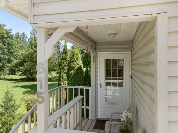 a living room with furniture floor to ceiling window and wooden floor