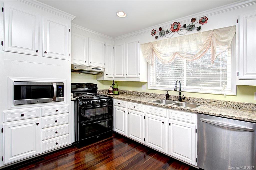 918 Lansdowne Road Charlotte, NC 28270 - Photo 4 of 24 a kitchen with granite countertop white cabinets and white appliances