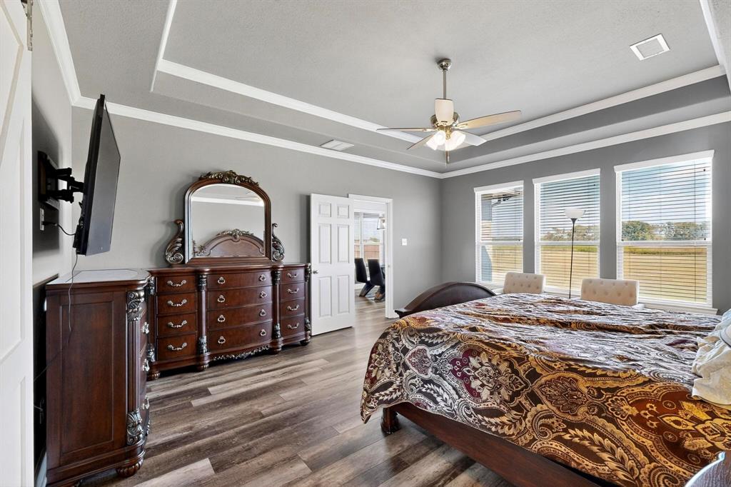 634 Gant Road Sherman, TX 75090 - Photo 18 of 40 Bedroom with a tray ceiling, dark wood finished floors, ceiling fan, and ornamental molding