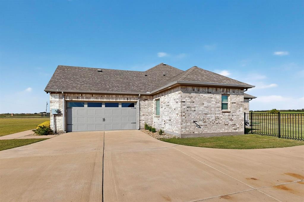 634 Gant Road Sherman, TX 75090 - Photo 35 of 40 View of side of home with a shingled roof, concrete driveway, and an attached garage