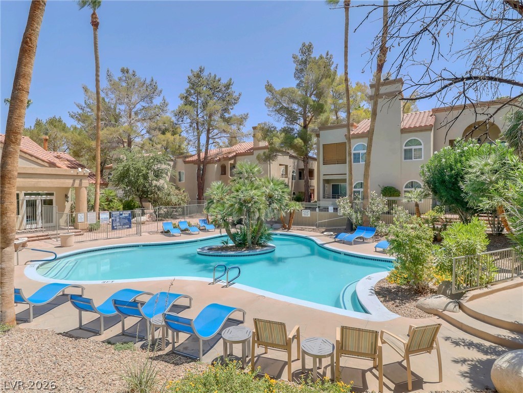 3145 East Flamingo Road, Unit 2129 Las Vegas, NV 89121 - Photo 35 of 43 A refreshing pool with surrounding lounge chairs, nestled within a vibrant community landscape.