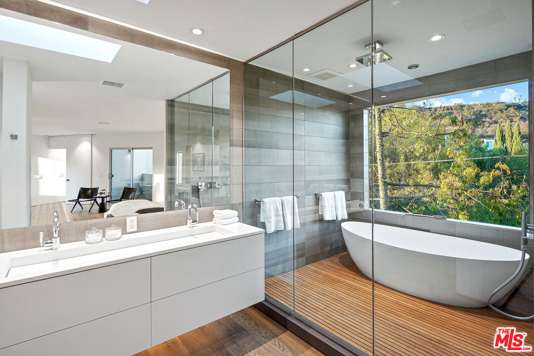 7187 Macapa Drive Los Angeles, CA 90068 - Photo 26 of 39 a bathroom with a large tub a sink and large windows