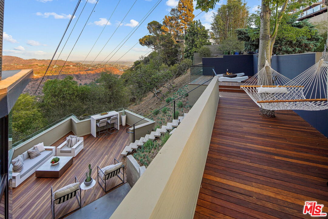 7187 Macapa Drive Los Angeles, CA 90068 - Photo 30 of 39 a balcony with wooden floor table and chairs