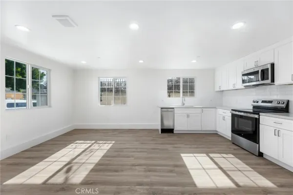 a kitchen with stainless steel appliances granite countertop a stove a sink and a microwave