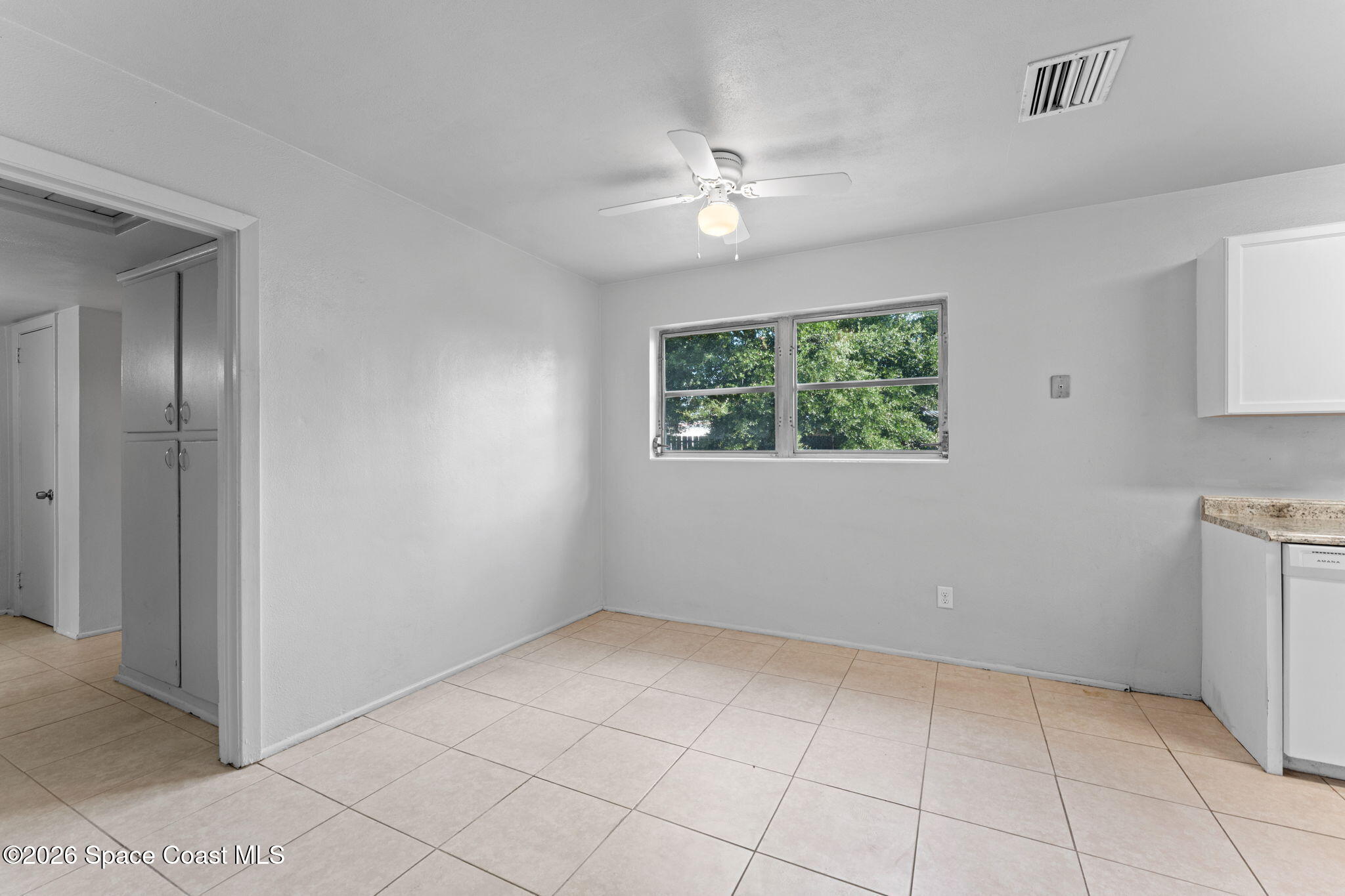 1042 Azalea Lane Cocoa, FL 32922 - Photo 7 of 26 a view of an empty room with window and chandelier fan