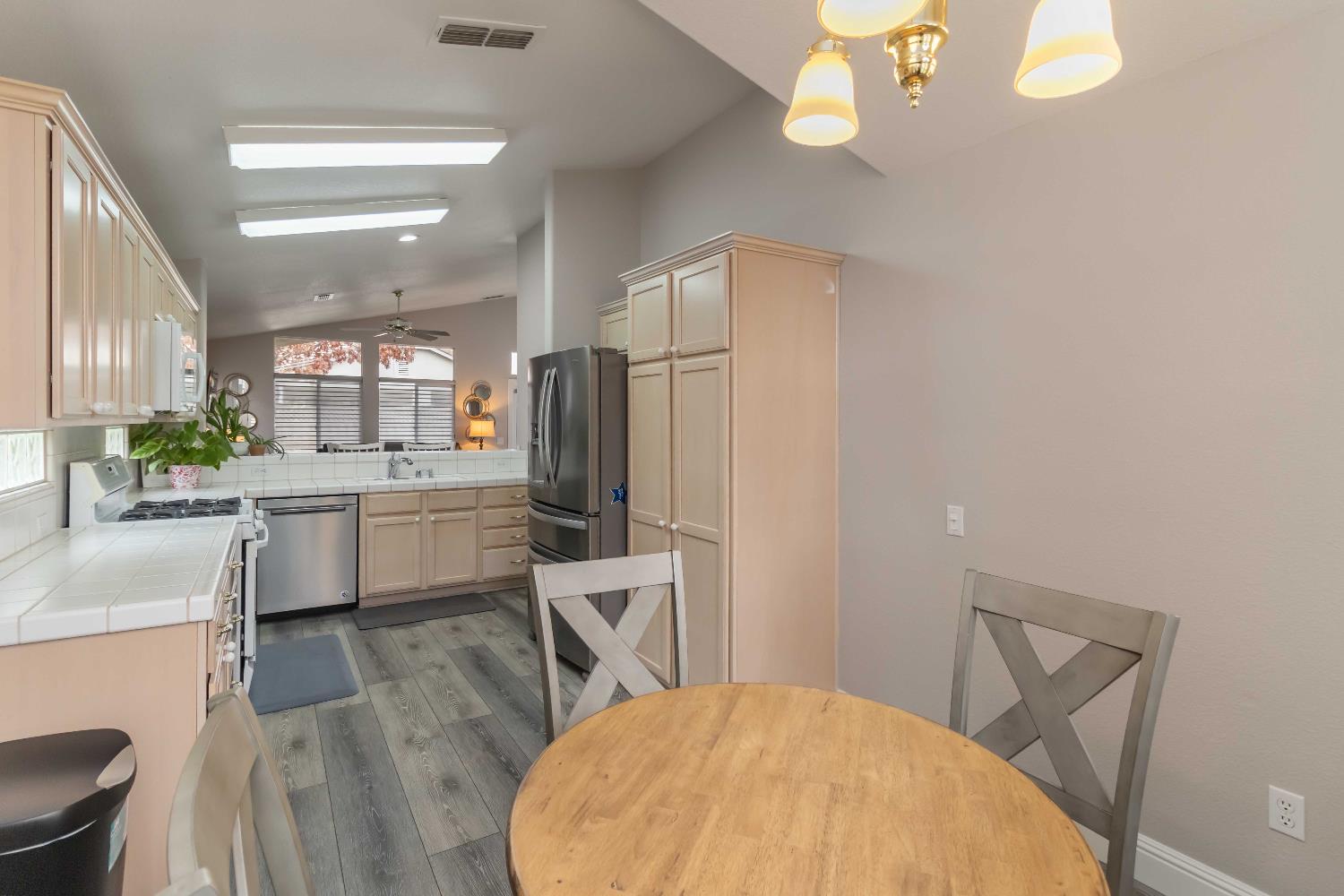 7597 Timberrose Way Roseville, CA 95747 - Photo 12 of 30 a kitchen with a table chairs refrigerator and microwave