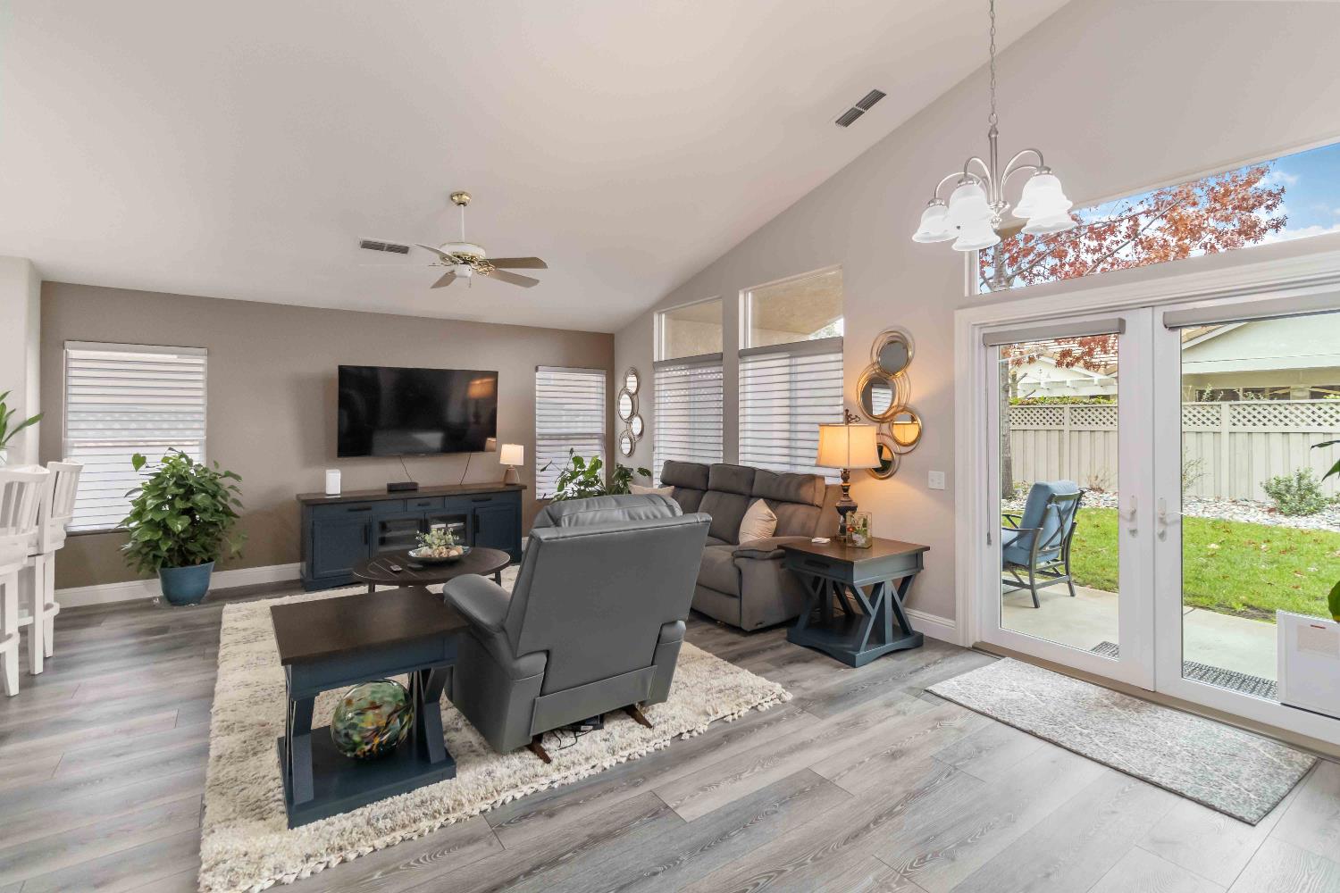 7597 Timberrose Way Roseville, CA 95747 - Photo 16 of 30 a living room with furniture a chandelier and a flat screen tv