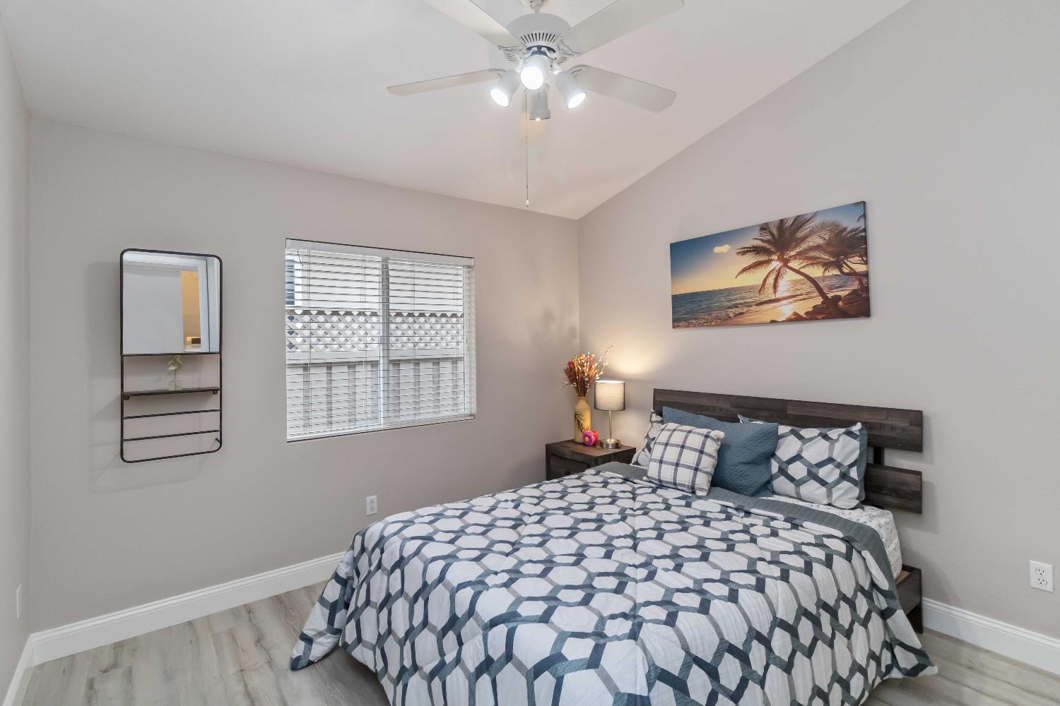 7597 Timberrose Way Roseville, CA 95747 - Photo 20 of 30 a bedroom with a large bed and a chandelier