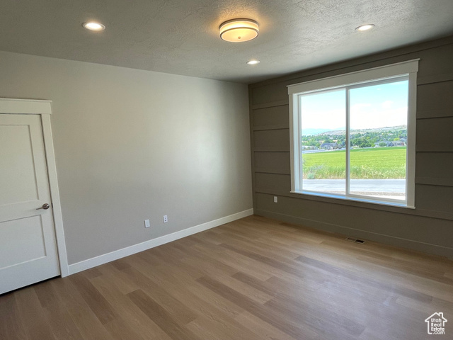 658 West 500 South Logan, UT 84321 - Photo 18 of 25 Empty room featuring a textured ceiling, light wood-style floors, and recessed lighting